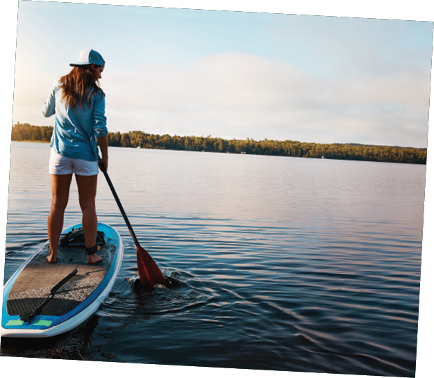 Shot of a young woman paddle boarding on a lake