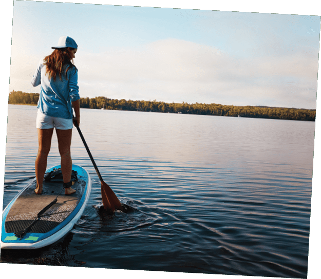 Shot of a young woman paddle boarding on a lake