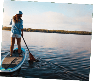 Shot of a young woman paddle boarding on a lake